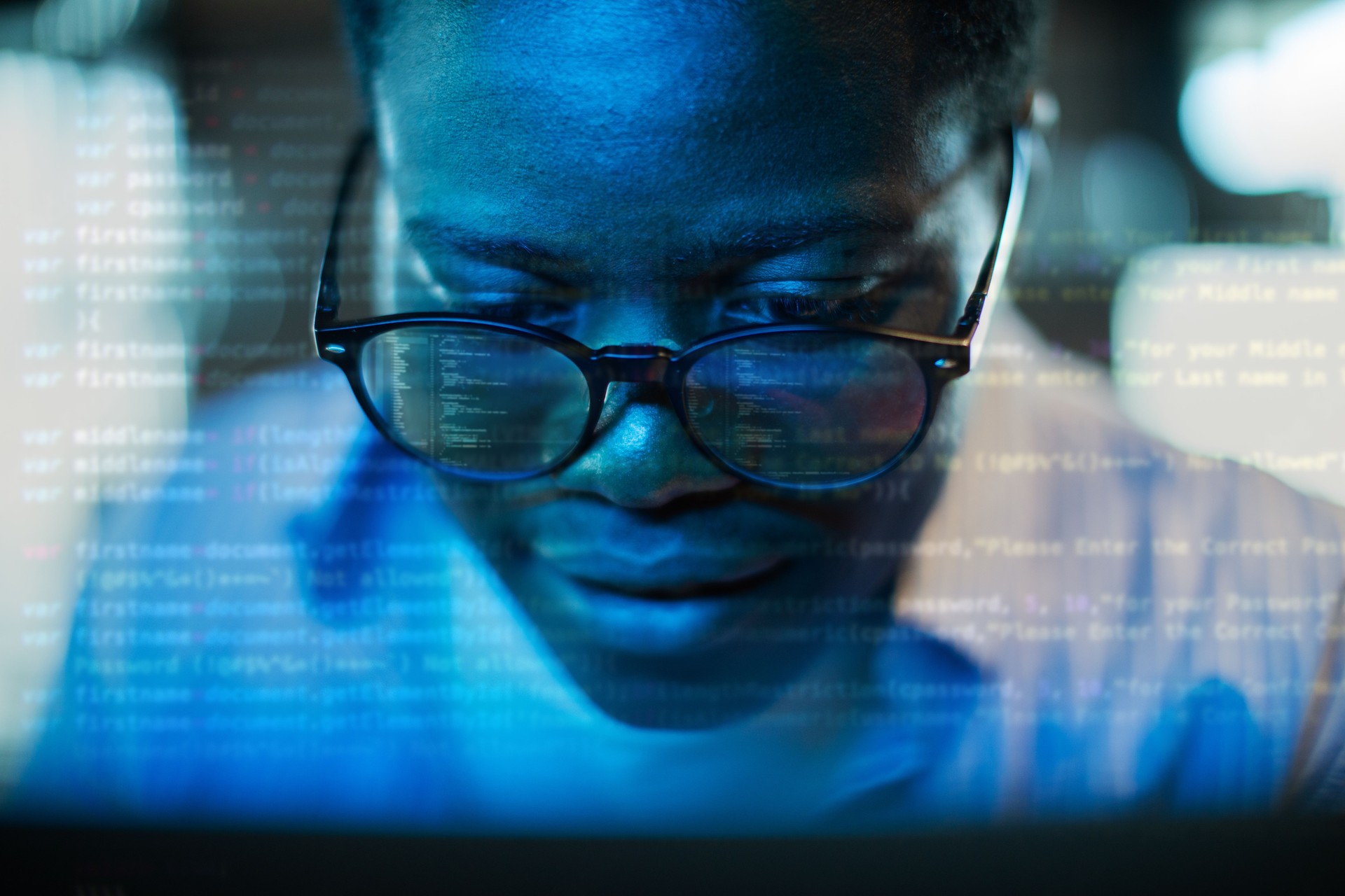 Young adult black programmer coding using laptop